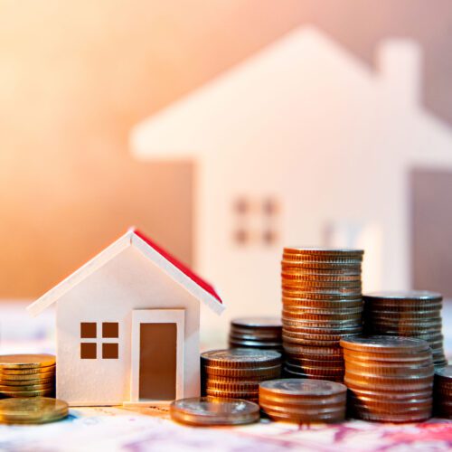 Real estate or property investment. Home mortgage loan rate. Saving money for retirement concept. Coin stack on international banknotes with house model on table. Business growth background