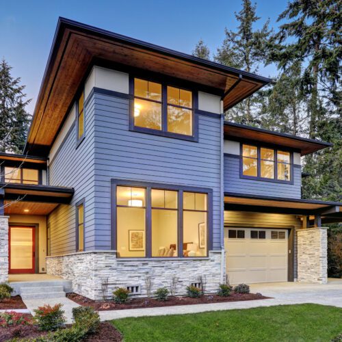 Luxurious new construction home in Bellevue, WA. Modern style home boasts two car garage framed by blue siding and natural stone wall trim. Northwest, USA